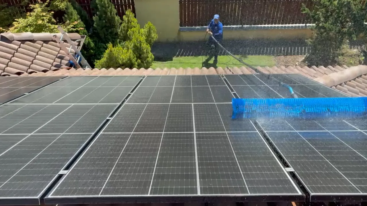 CleanSolar szakember kíméletes kefével tisztítja a napelemeket