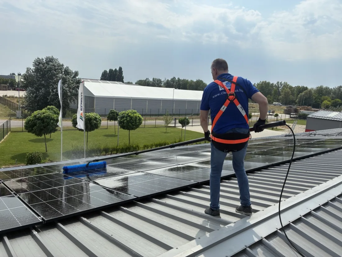 Munkás ipari tetőn, rendezvénysátor háttérrel